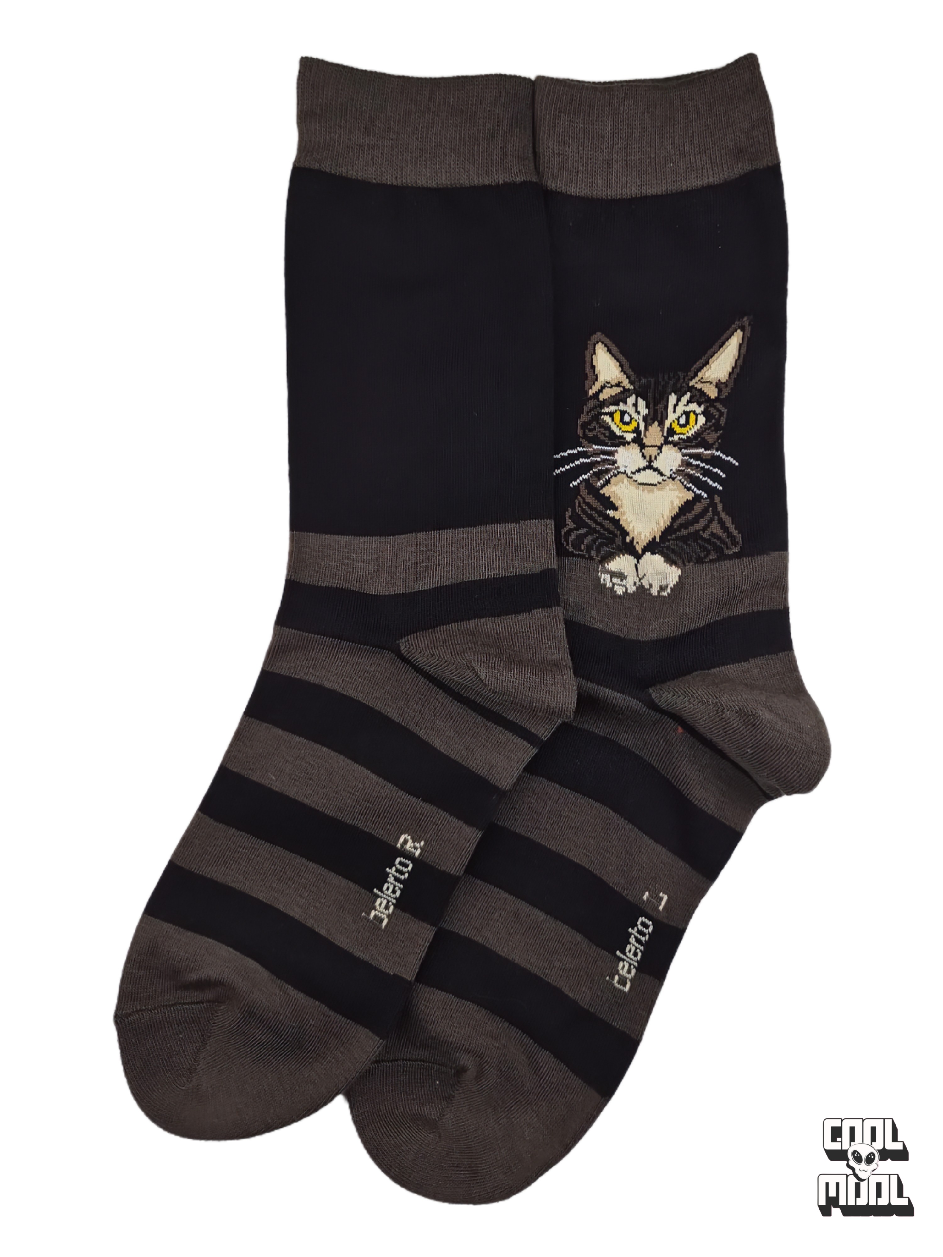 Curious brown and black tabby cat with bright yellow eyes resting its paws on a ledge woven crew socks made of charcoal grey and black striped cotton fabric.