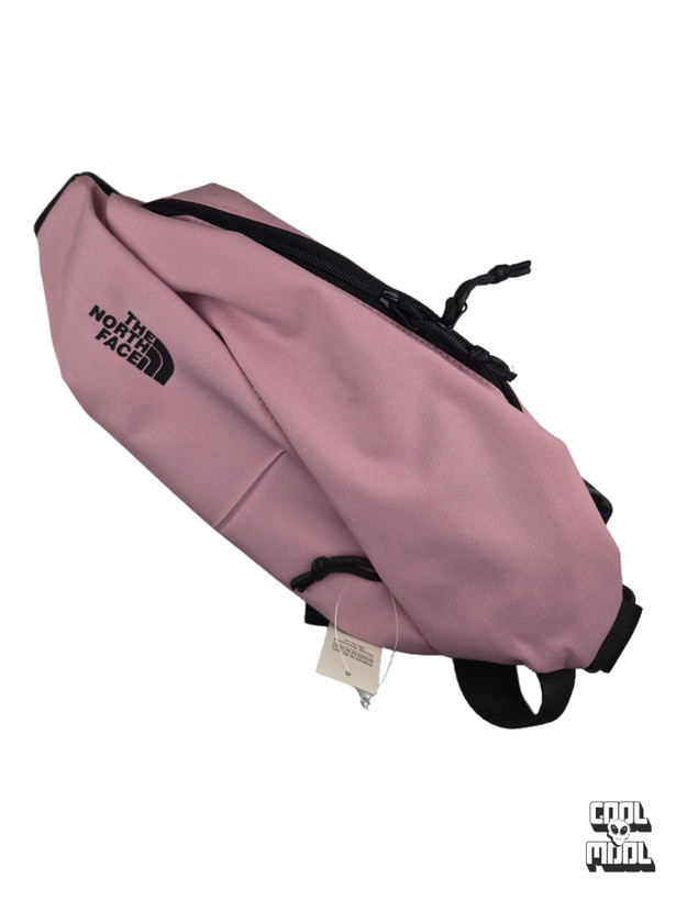 Dusty pink The North Face fanny pack and crossbody bag featuring black zippers, adjustable strap, and sturdy buckle clip.
